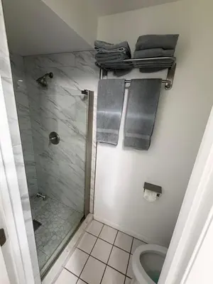 a bathroom with a shower and a toilet and towels at Perfecto Mundo 1, Orlando Area 5BR-2BA Outdoor Pool, Ping Pong, Billiard in Orlando