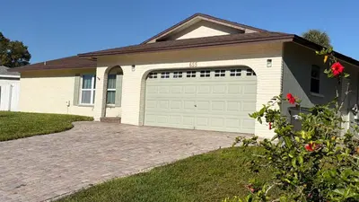 a house with a garage door and a driveway at Perfecto Mundo 1, Orlando Area 5BR-2BA Outdoor Pool, Ping Pong, Billiard in Orlando