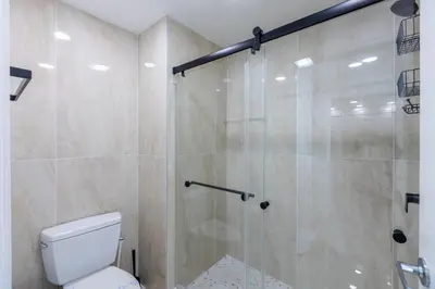 a bathroom with a shower and a toilet at Modern Unit w Themed Room, Full Kitchen and Prime Location in Orlando