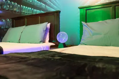 a bedroom with two beds with a headboard and a lamp at Wizard Themed Suite near Universal and Epic in Orlando