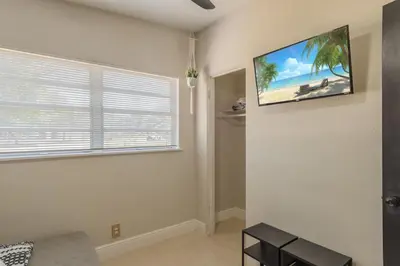 a living room with a flat screen tv on the wall at Jacuzzi and Games Close to Dwtn Disney and Parks in Orlando