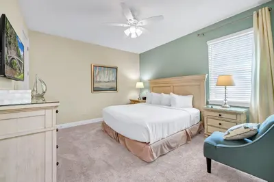 a bedroom with a white bed and a blue chair at Home With Theme Room, Private Pool & Game Room Near Disney With Waterpark And Resort Access At Encore Resort Reunion - 471La in Orlando