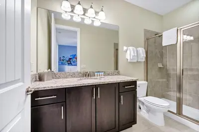 a bathroom with a sink and a toilet and a mirror at Home With Theme Room, Private Pool & Game Room Near Disney With Waterpark And Resort Access At Encore Resort Reunion - 471La in Orlando