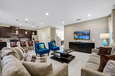 a living room with a couch and chairs and a kitchen at Home With Theme Room, Private Pool & Game Room Near Disney With Waterpark And Resort Access At Encore Resort Reunion - 471La in Orlando