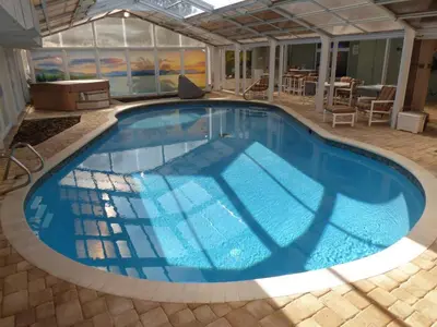 a large swimming pool with blue water at Perfecto Mundo 7, Orlando Area 6BR-2MB-3BR Indoor Pool, Ping Pong, Jacuzzi, Disney in Orlando