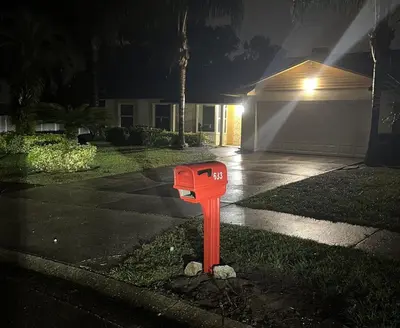 a red mailbox in the yard of a house at night at Perfecto Mundo 7, Orlando Area 6BR-2MB-3BR Indoor Pool, Ping Pong, Jacuzzi, Disney in Orlando