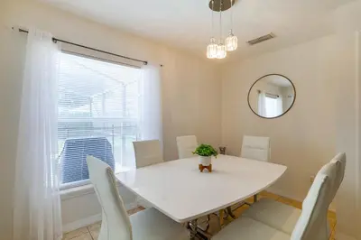 a white dining room with a white table and chairs at Peaceful Clermont Gem with Pool, 9 Mi to Disney! in Orlando