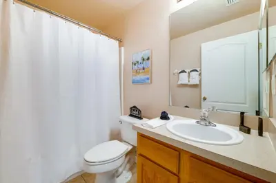 a bathroom with a toilet and a sink and a mirror at Peaceful Clermont Gem with Pool, 9 Mi to Disney! in Orlando