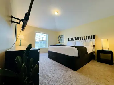 a bedroom with a large bed and a cactus at Luxury Family Villa with Pool Near Disney Parks in Kissimmee