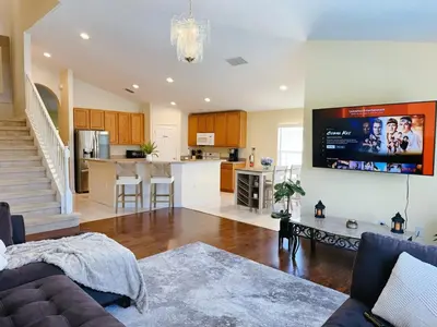 a living room with a couch and a kitchen at Luxury Family Villa with Pool Near Disney Parks in Kissimmee