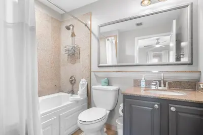 a bathroom with a toilet and a sink and a mirror at 13415 Blue Heron Beach Dr 1-708 in Orlando