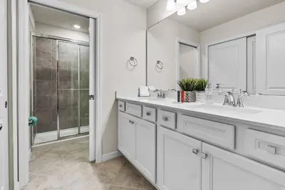 a white bathroom with two sinks and a shower at Brand New 05 Bedrooms At Windsor Cay in Orlando