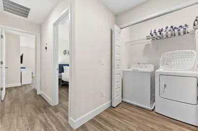 a kitchen with white cabinets and a washer and dryer at 4461 Summer Flowers Pl in Kissimmee