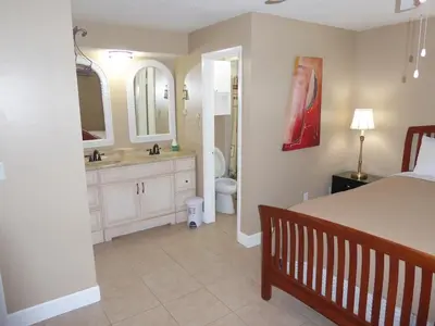 a bedroom with a bed and a bathroom with a sink at Perfecto Mundo 6, Orlando Area 4BR-2MB-3Bath Huge Pool, Ping Pong, Billiard, Disney Universal in Orlando