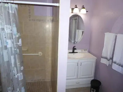 a bathroom with a sink and a shower with a mirror at Perfecto Mundo 6, Orlando Area 4BR-2MB-3Bath Huge Pool, Ping Pong, Billiard, Disney Universal in Orlando
