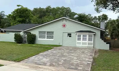 a green house with a clock on top of it at Perfecto Mundo 6, Orlando Area 4BR-2MB-3Bath Huge Pool, Ping Pong, Billiard, Disney Universal in Orlando