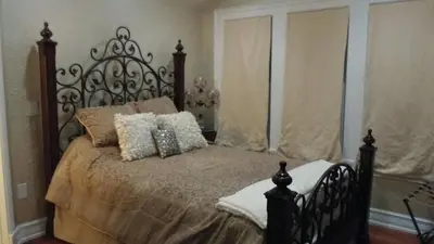a bedroom with a bed with a metal headboard and pillows at Kapp and Kappy Bed & Breakfast in Kissimmee