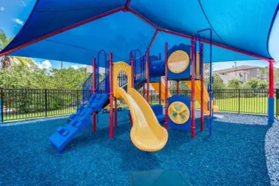 a playground with a slide in a blue canopy at Apartamento 3 Quartos no Vista Cay Resort in Orlando
