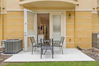 a patio with chairs and a table and a grill at Apartamento 3 Quartos no Vista Cay Resort in Orlando