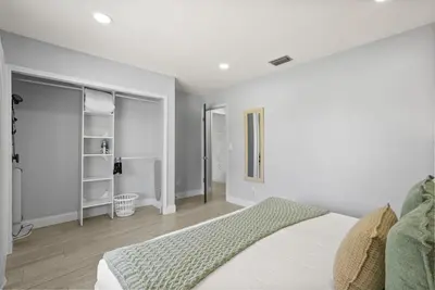 a white bedroom with a bed and a room with a closet at Modern Escape Near Lake Eola and Downtown Orlando in Orlando