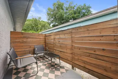 a fence with two chairs and a table on a patio at Modern Escape Near Lake Eola and Downtown Orlando in Orlando