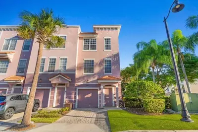 a pink house with palm trees in front of it at Townhouse Moderna no Vista Cay in Orlando