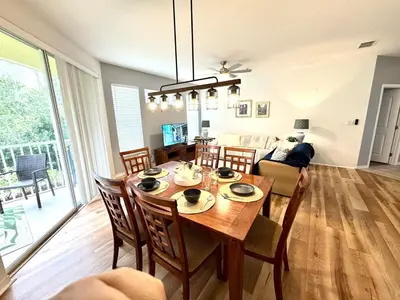 a dining room and living room with a table and chairs at Wonderful apt remodeled in November near Disney in Kissimmee