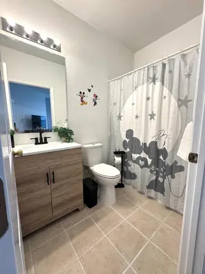 a bathroom with a toilet and a sink and a shower curtain at Wonderful apt remodeled in November near Disney in Kissimmee