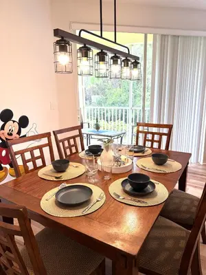 a wooden dining room table with chairs and a panda bear at Wonderful apt remodeled in November near Disney in Kissimmee