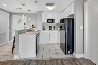 a kitchen with white cabinets and a black refrigerator at 6165 CD Unit 3603 - Enclave at Orlando Condo in Orlando