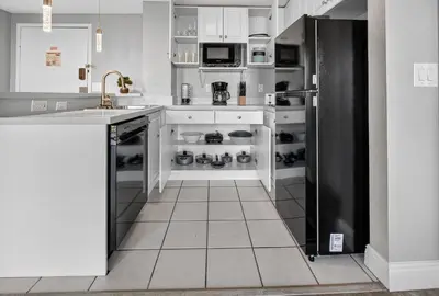 a kitchen with white cabinets and a black refrigerator at 6165 CD Unit 3603 - Enclave at Orlando Condo in Orlando
