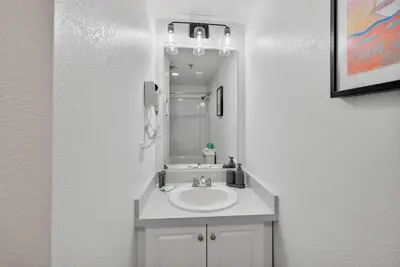 a white bathroom with a sink and a mirror at 6165 CD Unit 3603 - Enclave at Orlando Condo in Orlando