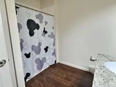 a bathroom with a shower curtain with mice on it at Casa 3Q Lucaya Village — 15min da Disney in Kissimmee