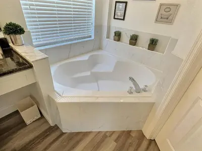 a white bath tub in a bathroom with a window at Casa 4Q c/ Piscina Aquecida — Lake Berkley in Kissimmee