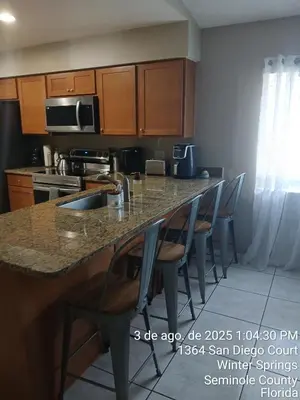 a kitchen with a counter with chairs around it at Maxx Maximum Comfort LLC in Orlando
