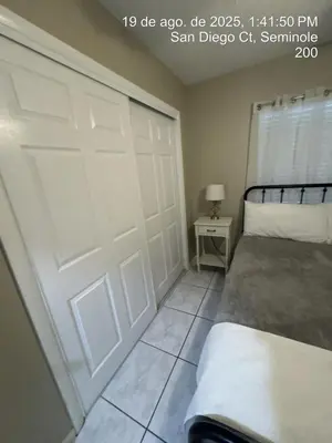 a bedroom with a white garage door and a bed at Maxx Maximum Comfort LLC in Orlando