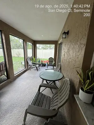 a patio with a table and chairs and windows at Maxx Maximum Comfort LLC in Orlando