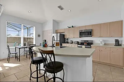 a kitchen with a counter and some chairs in it at Mickeys Villa in Kissimmee
