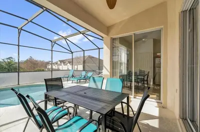 a patio with a table and chairs and a pool at Mickeys Villa in Kissimmee