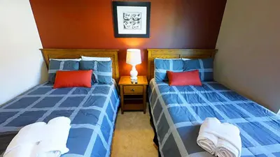 two beds in a bedroom with blue and red pillows at Cozy 3 BD Townhome 2 king beds Close to Disney 1503 in Kissimmee