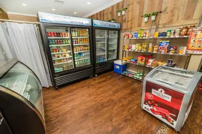 a grocery store aisle with a cooler and shelves of food at Cozy 3 BD Townhome 2 king beds Close to Disney 1503 in Kissimmee