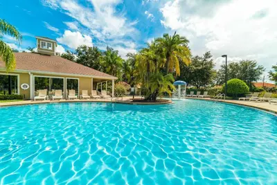 a swimming pool at a resort with palm trees at Cozy 3 BD Townhome 2 king beds Close to Disney 1503 in Kissimmee
