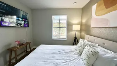 a bedroom with a white bed and a window at Park Hopper Paradise At Regal Oaks in Orlando