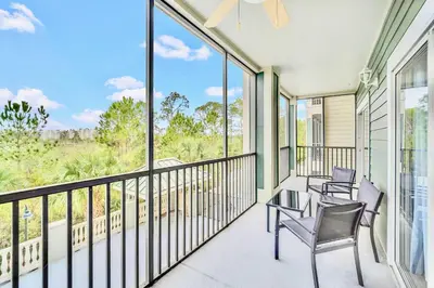 a balcony with chairs and windows with a view at Family Fun Condo Pool and Sauna near Disney in Orlando