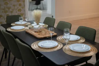 a black table with plates and wine glasses on it at Entire Home with Pool, Ping Pong Table and Arcade games in Kissimmee