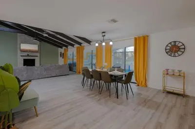 a dining room and living room with a table and chairs at Entire Home with Pool, Ping Pong Table and Arcade games in Kissimmee