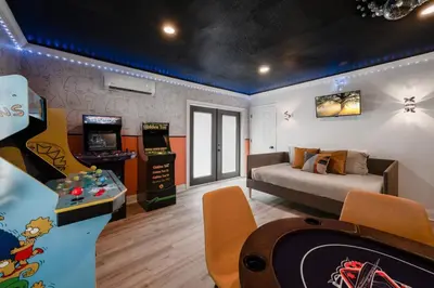 a living room with a couch and a video game at Entire Home with Pool, Ping Pong Table and Arcade games in Kissimmee