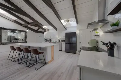 a kitchen with a large island with bar stools at Entire Home with Pool, Ping Pong Table and Arcade games in Kissimmee