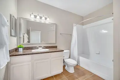 a bathroom with a sink and a toilet and a mirror at Upstay Pet Friendly Condo 6 Minutes from Disney in Orlando