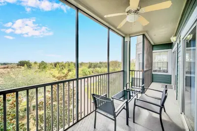 a balcony with two chairs and a ceiling fan at Upstay Pet Friendly Condo 6 Minutes from Disney in Orlando